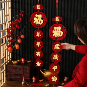 Red Chinese New Year couplets with gold calligraphy hanging on a door, symbolizing prosperity and good fortune.